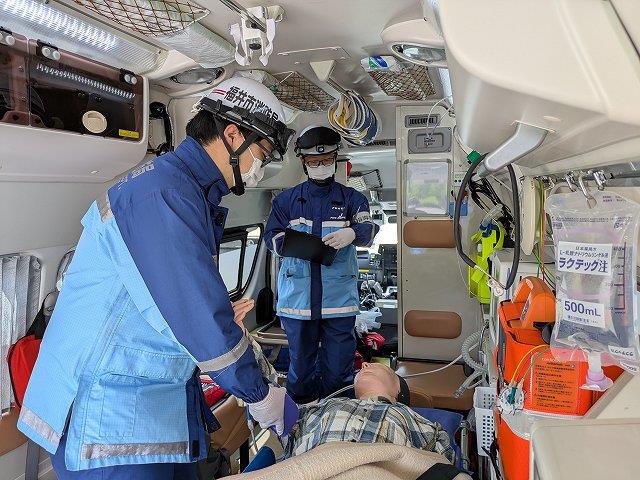 救急車内で活動する救急隊員とそれを評価する指導救命士